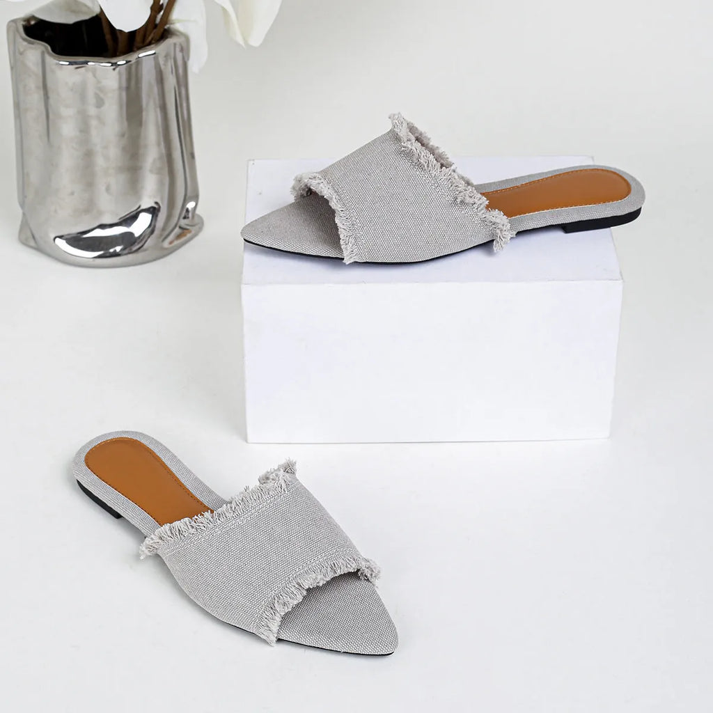 Women's denim flat slippers with tassel detail and leather lining in various colours.