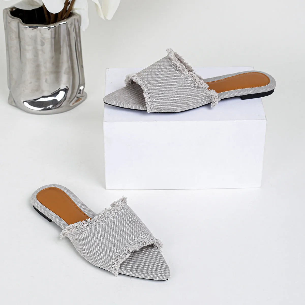 Women's denim flat slippers with tassel detail and leather lining in various colours.