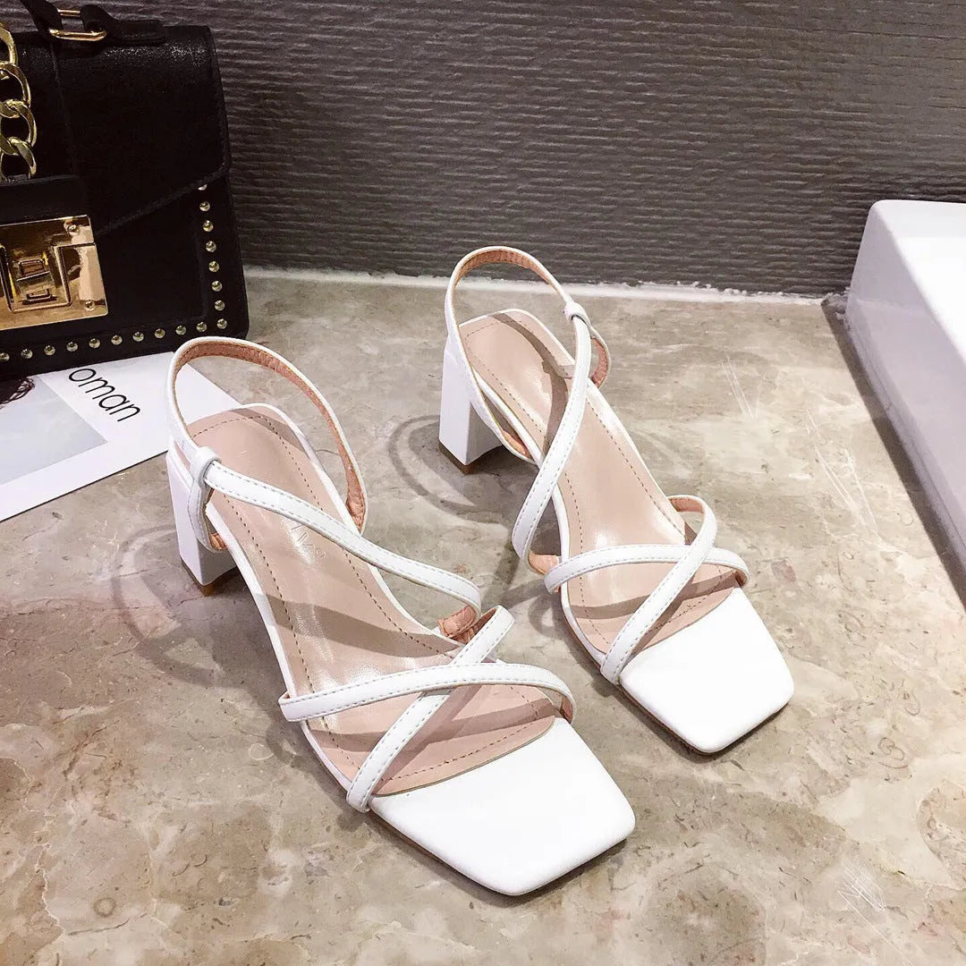 Women's white thick-heeled slip-on sandals with a high middle heel and open back.