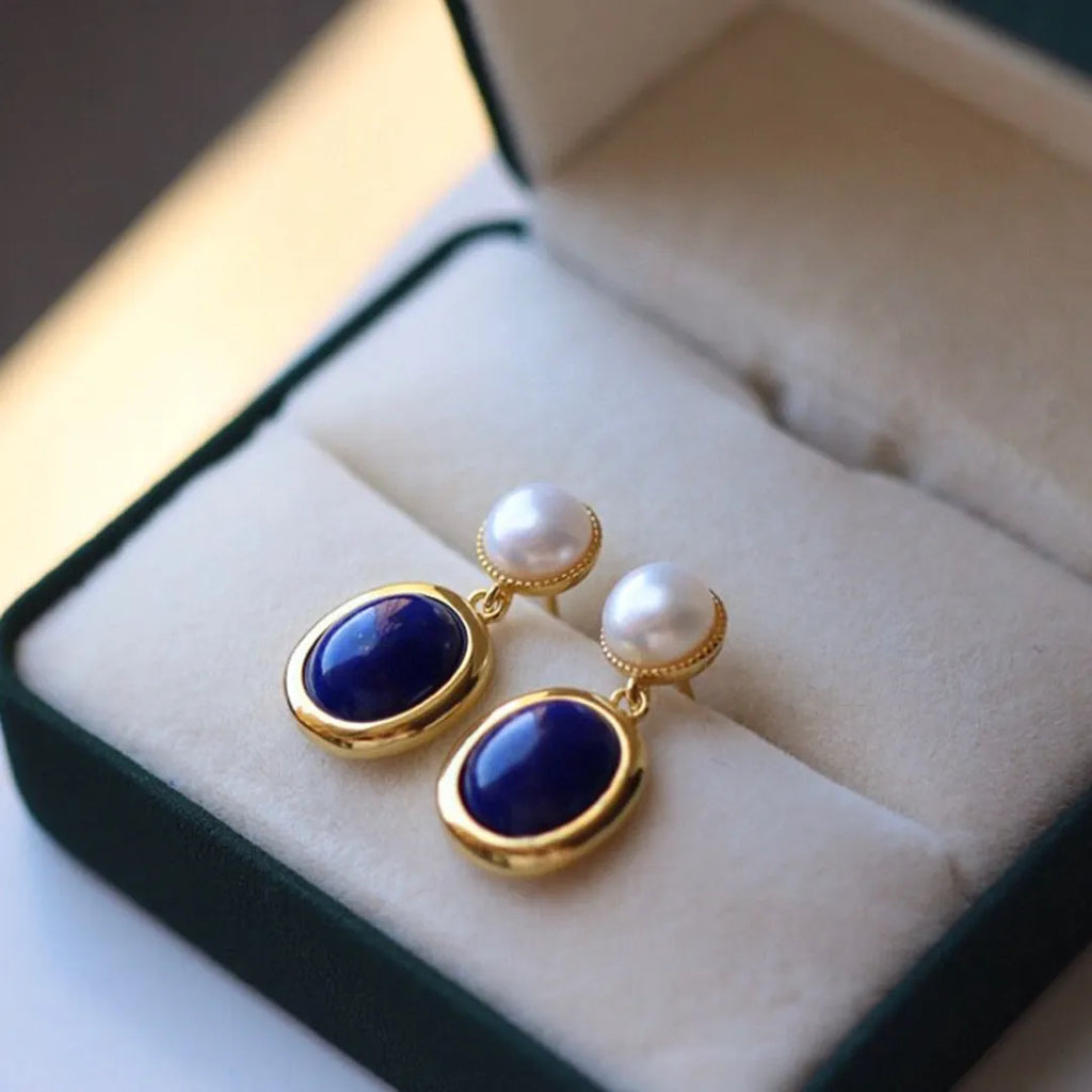 A pair of simple stud earrings with a blue lapis lazuli pearl set in sterling silver.