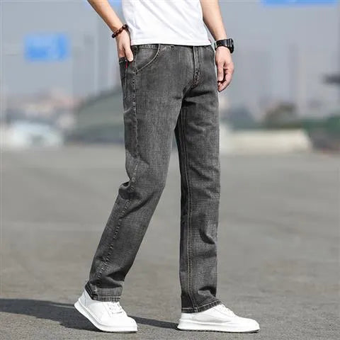 Man wearing smoky grey straight leg men's jeans with a low waist and zip fly.