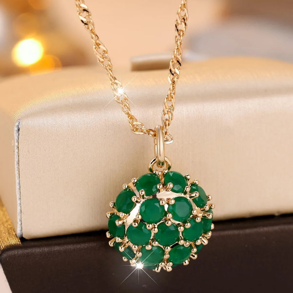 Women's champagne gold necklace with round emerald pendant and diamond accents on copper chain