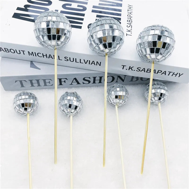 Glass disco ball cake decoration on a wooden stick, shown in different sizes for cake topping.