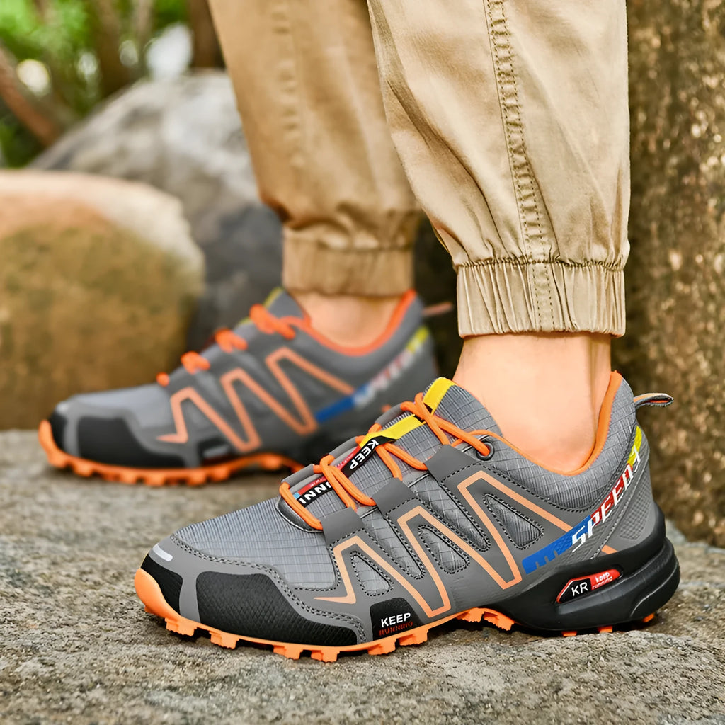 Men's low-top casual running shoe in synthetic leather with mesh lining, shown in grey orange colourway.