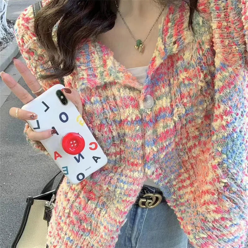 Pink and green retro style slim-fit knitted cardigan sweater on a hanger.