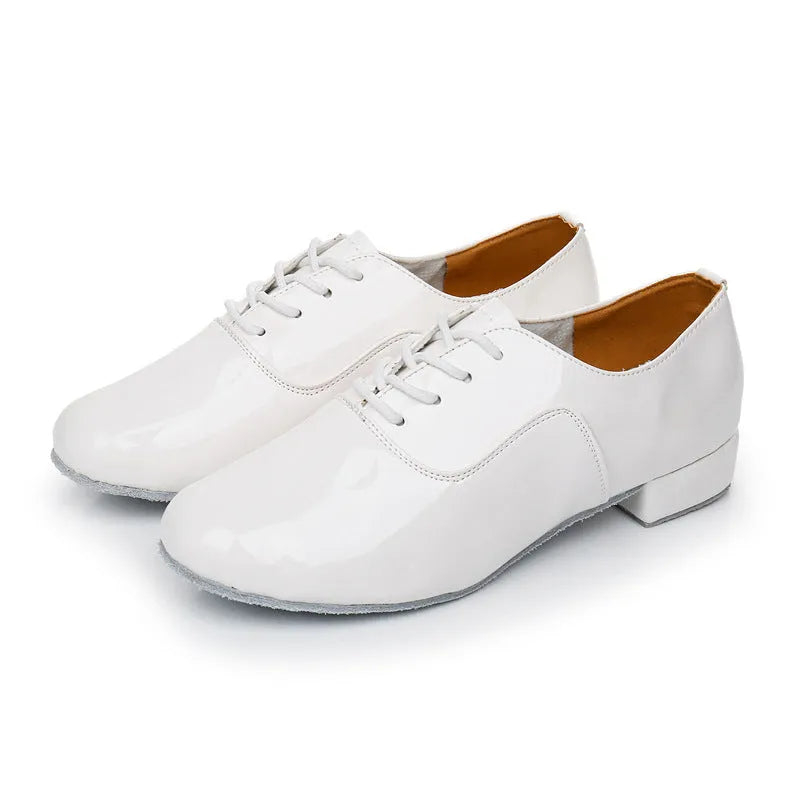 Men's black dancing shoes with a synthetic leather upper and calf leather sole, shown on a studio floor.