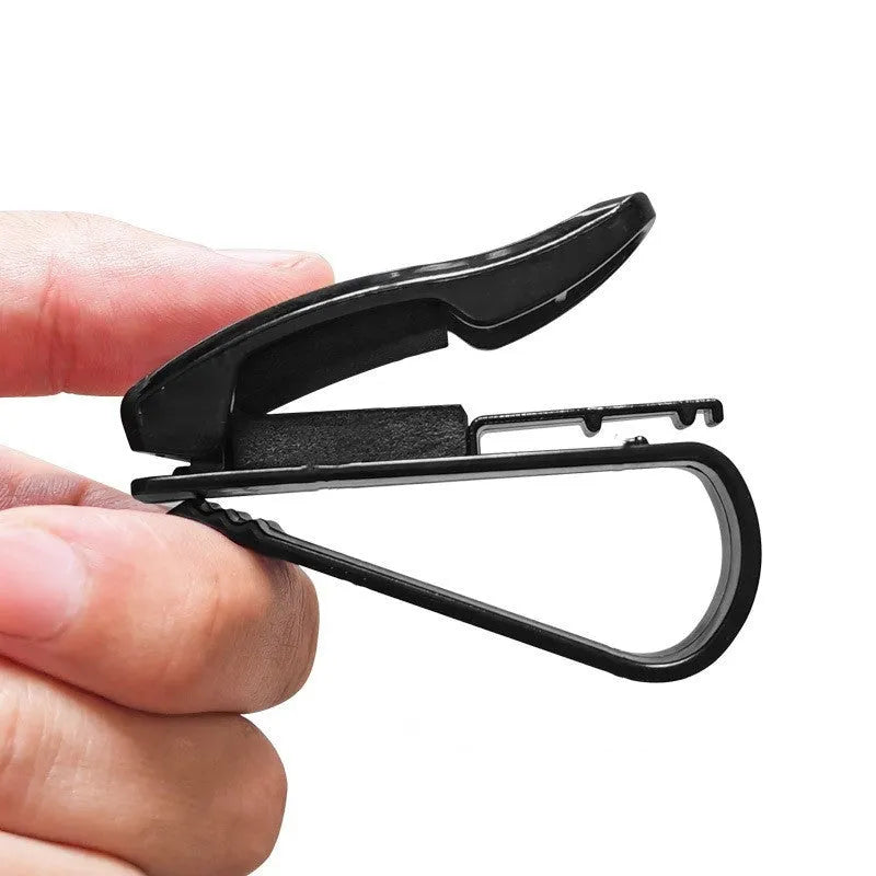 Black plastic clip for holding glasses and cards on a car sun visor.