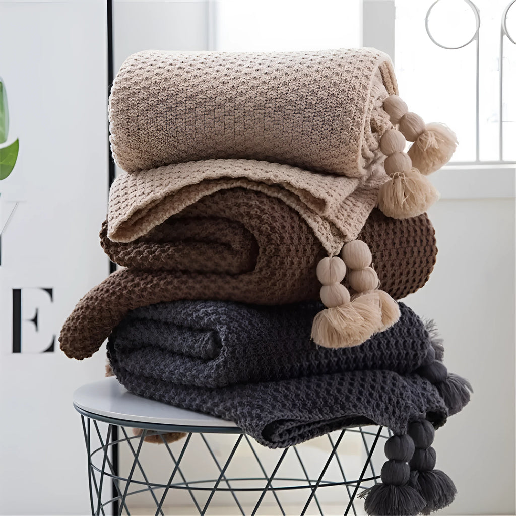 Nordic fringed knit ball acrylic blanket in beige colour, laid flat showing 130x170cm size and fringe detail