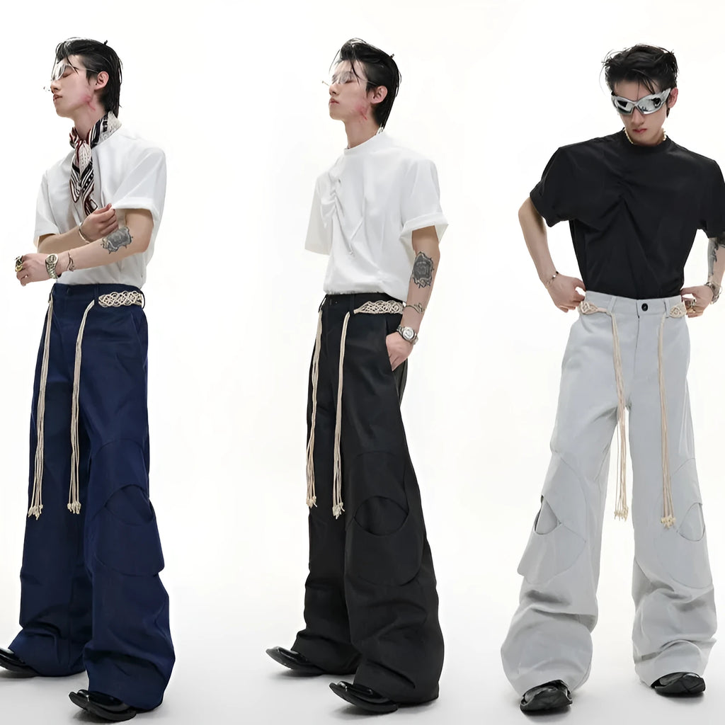 Men's dark blue straight-leg jeans with heavy 3D cutting, showing zipper decoration and tassel detail on a loose fit.