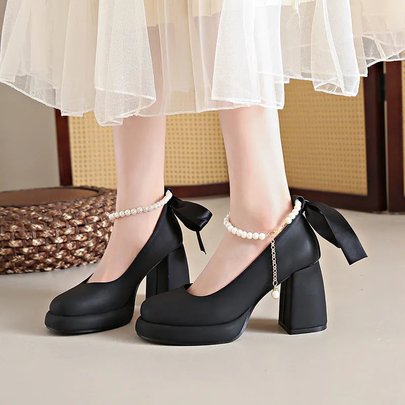 Women's beige Mary Jane shoes with chunky heel, round toe, and ankle strap with pearl buckle.