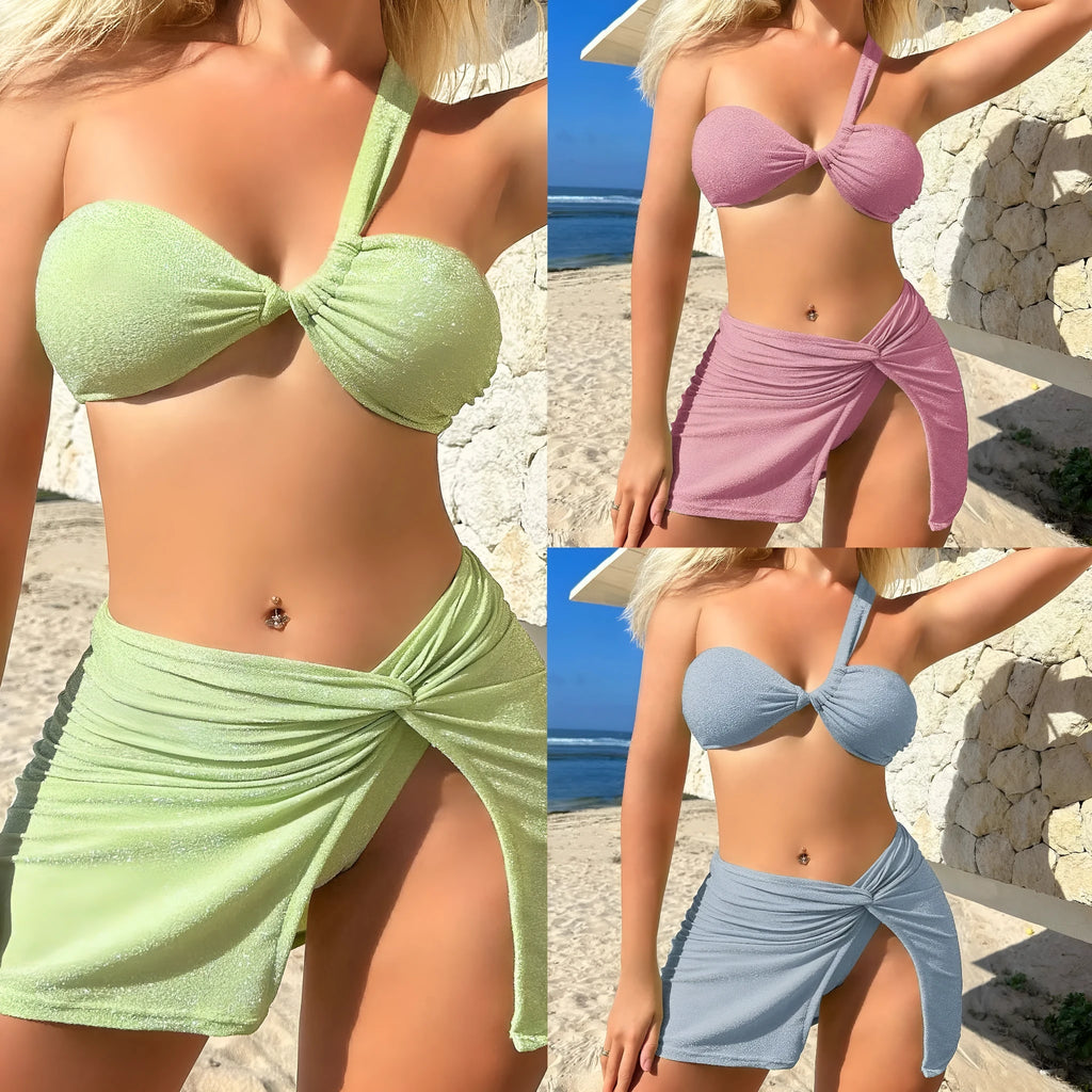 Women's light green one-shoulder swimsuit top with matching briefs and skirt laid flat.