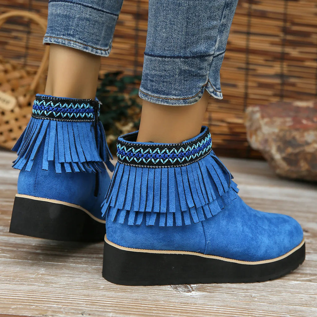 Women's dark brown suede wedge bootie with thick sole, side zipper, and tassel detail.