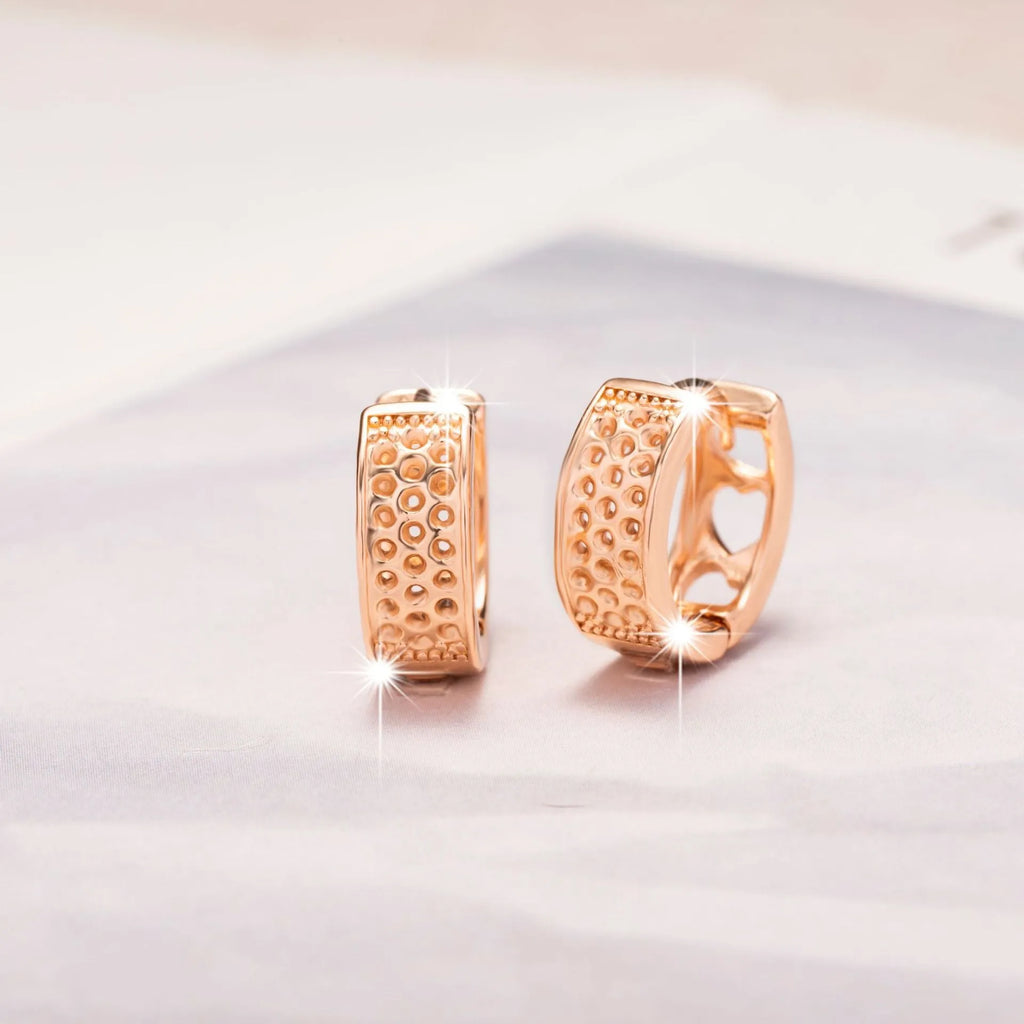 Rose gold women's earrings with three hollowed-out hearts in circular drop design