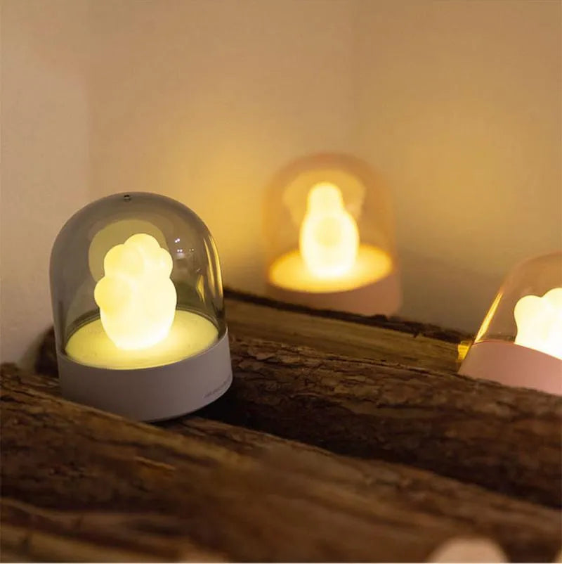 Grey and pink cat paw shaped USB rechargeable night light with adjustable brightness and musical rotation features