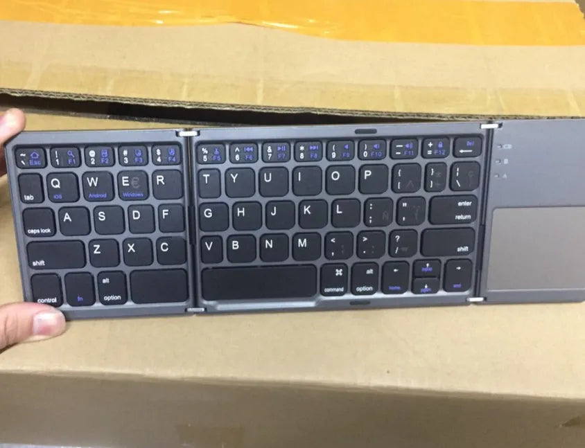 Black tri-fold folding Bluetooth keyboard with touchpad shown unfolded and folded