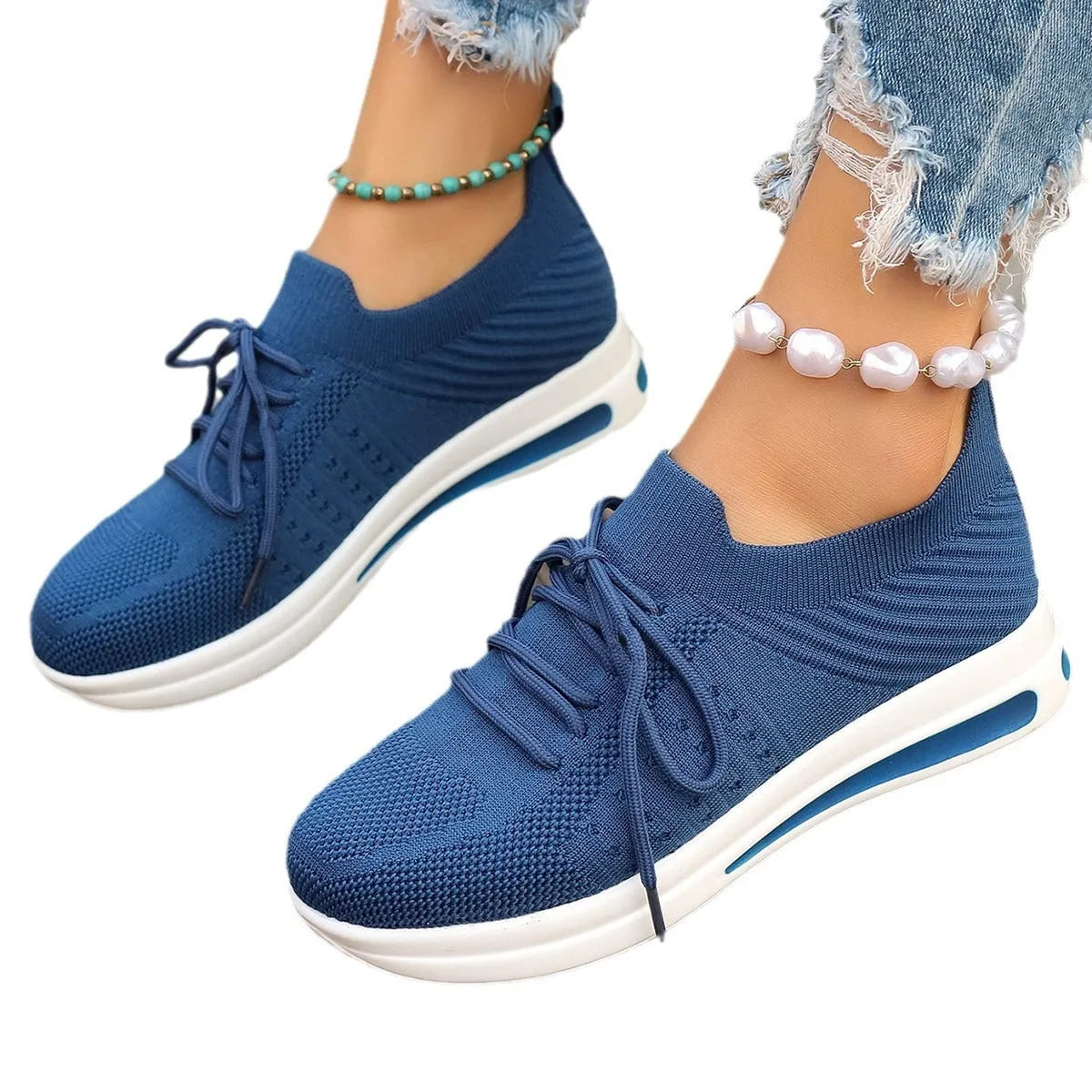 Women's low-top fly-knit sneakers in black, blue, or red with round toe and lace-up front.