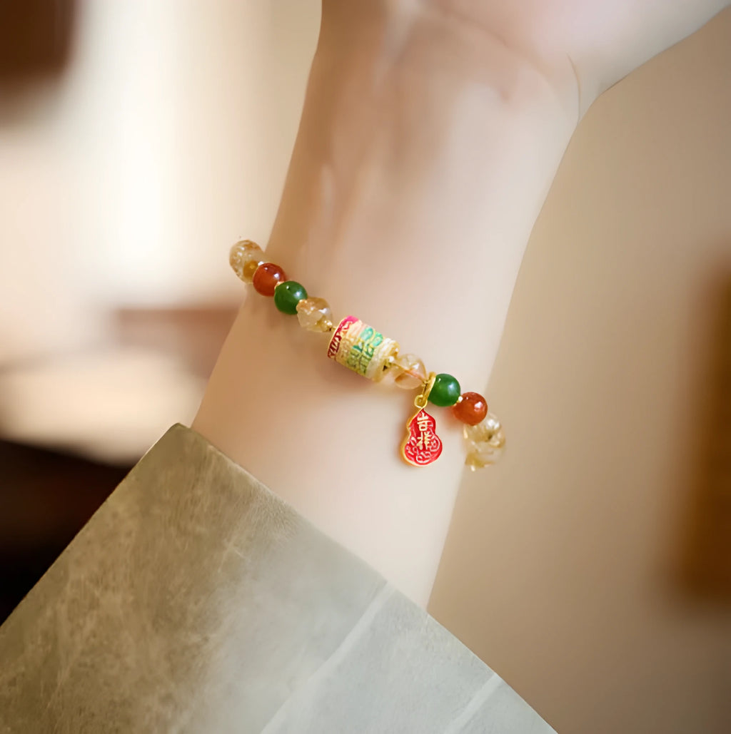 Hand-woven citrine five sutra bracelet with 6mm geometric beads on a wrist.