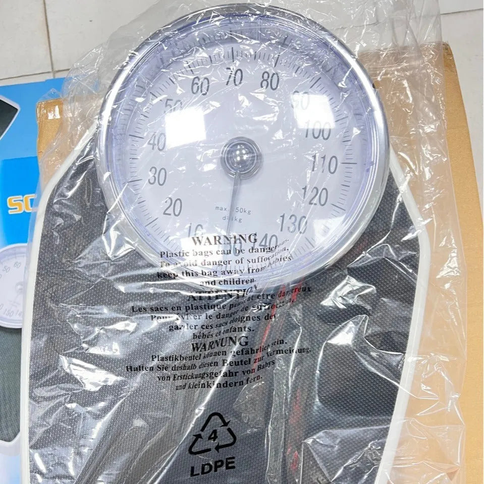 Black mechanical bathroom scales with large analogue dial showing weight measurements