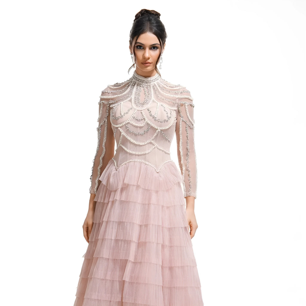 Black and pink women's long sleeve dress with beaded decoration on the front.