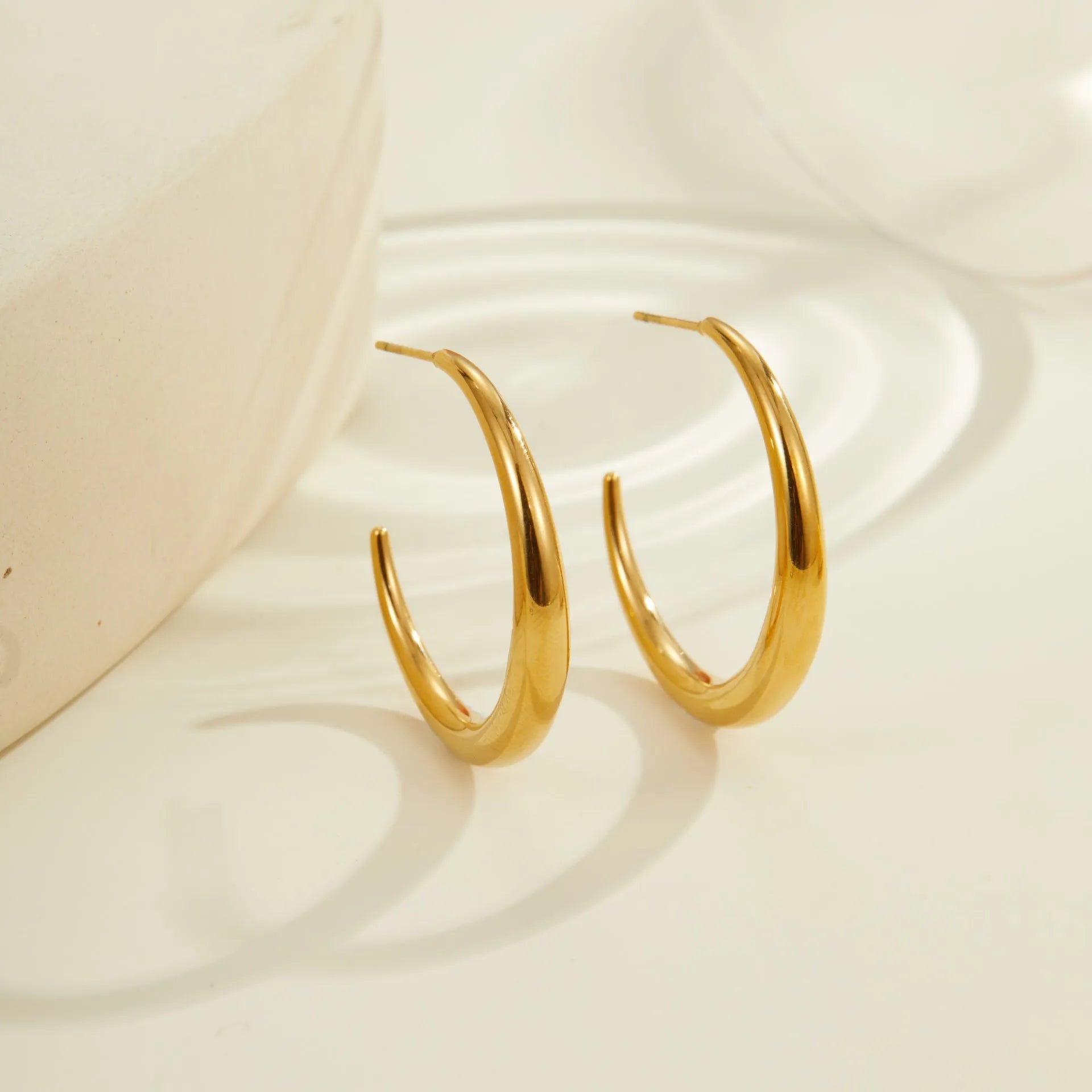 Titanium steel geometric hoop earrings with circular design and gold or steel finishes