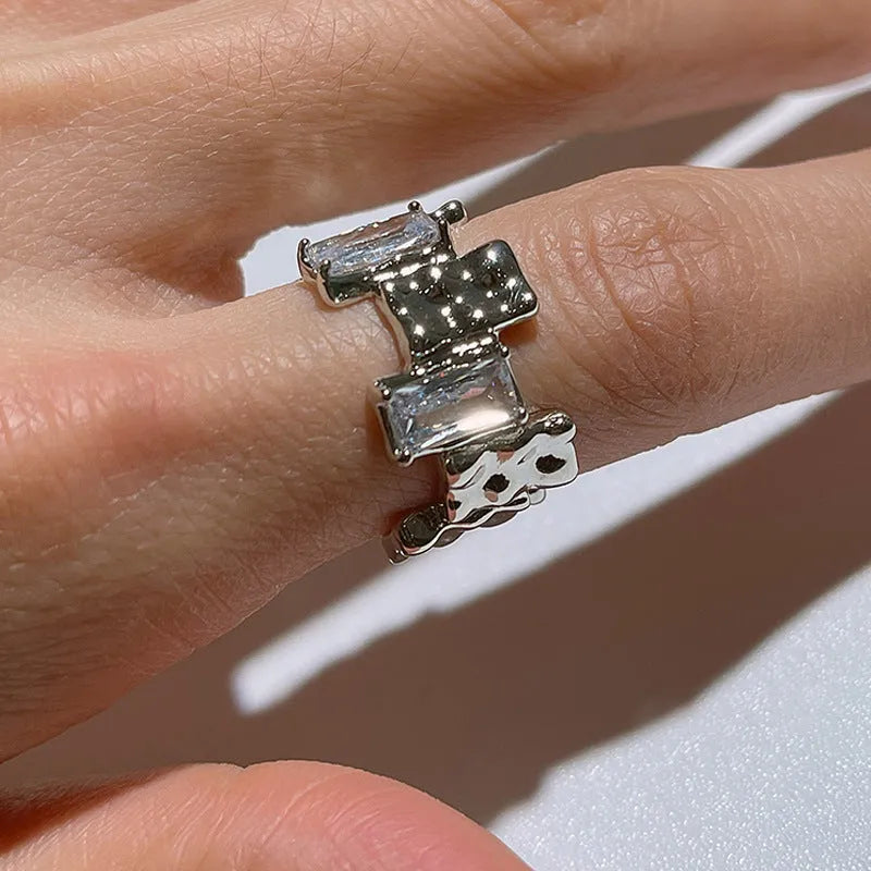 Silver geometric zircon cross ring with open centre and retro design