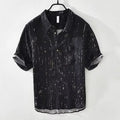A man's loose-fitting black lapel polo shirt with short sleeves on a hanger.