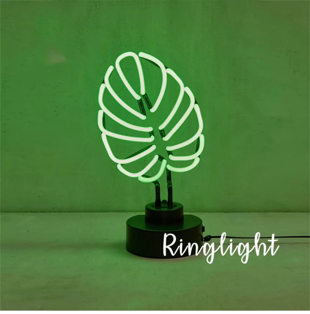 Minimalist white bamboo-shaped desk lamp emitting a soft green LED light, with a black USB cable.