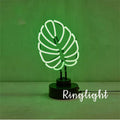 Minimalist white bamboo-shaped desk lamp emitting a soft green LED light, with a black USB cable.