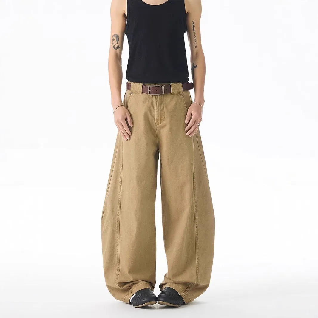 Brown men's loose-fit straight-leg jeans with a button fly on a mannequin.