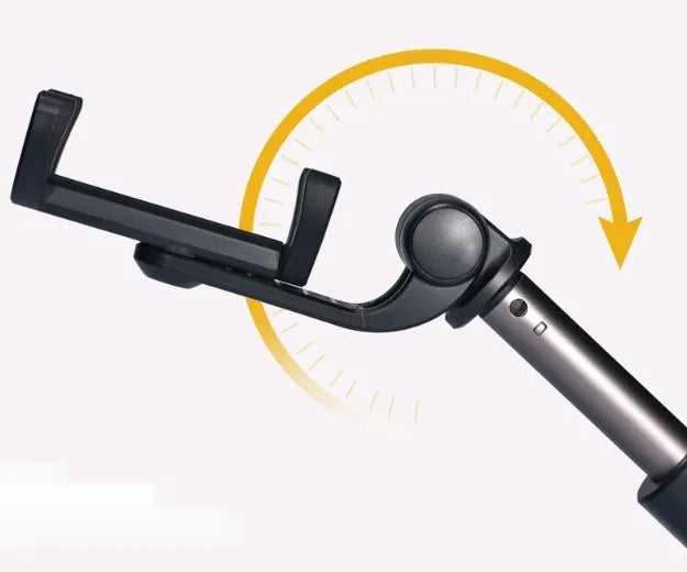 Black Bluetooth selfie stick tripod with remote control extended next to mobile phone