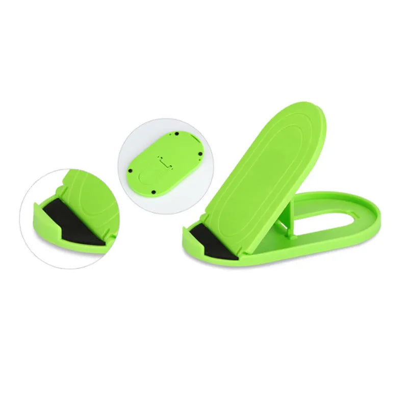 A lazy bracket style mobile phone stand made of plastic, shown in multiple colour options on a wooden desk.