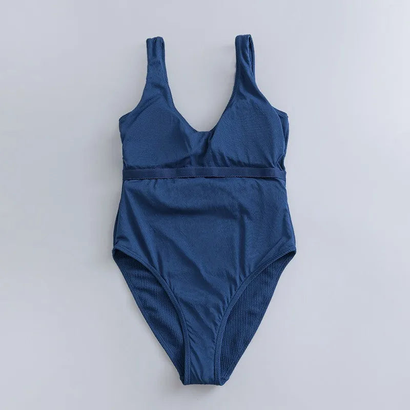 Navy blue women's one-piece slimming swimsuit with triangle top and chest pads on a white background.