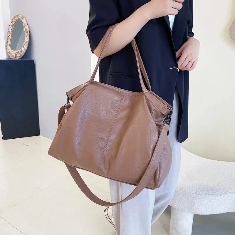 Large soft black PU messenger bag with car suture detail, shown with zip open revealing organiser pockets.
