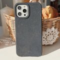 Fully degradable wheat straw bioplastic rear cover case for Apple iPhone on a table, shown in one of seven available colours.