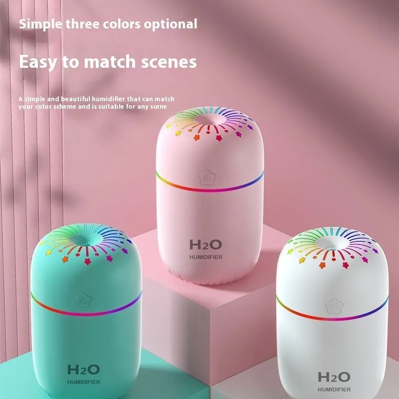 Small white Fireworks USB desktop humidifier with water tank on a wooden desk.