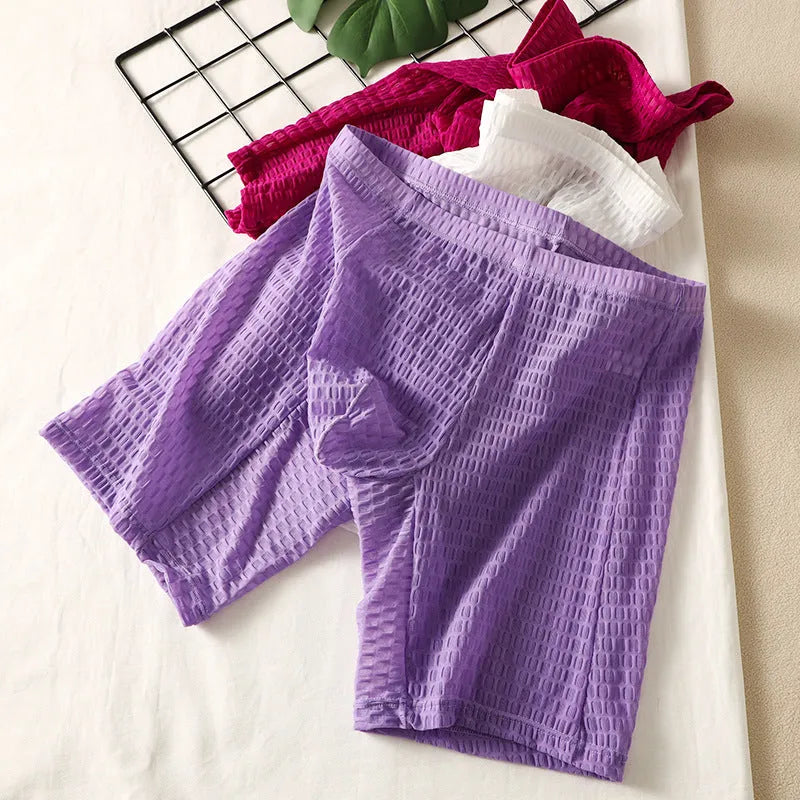 Men's lace boxer underwear in light purple on a grey background, showing the lengthened hip lift design.