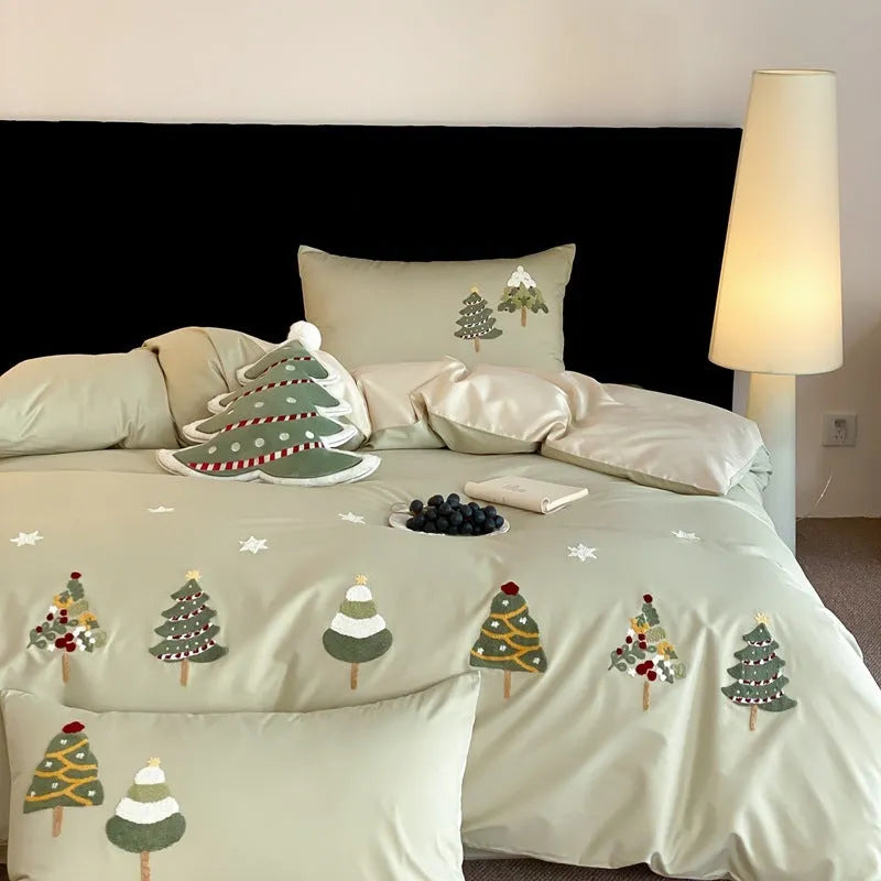 Cream blue Christmas tree embroidered pure cotton duvet cover, flat sheet, and pillowcases on a bed.