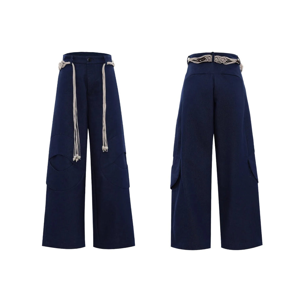 Men's dark blue straight-leg jeans with heavy 3D cutting, showing zipper decoration and tassel detail on a loose fit.