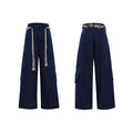 Men's dark blue straight-leg jeans with heavy 3D cutting, showing zipper decoration and tassel detail on a loose fit.