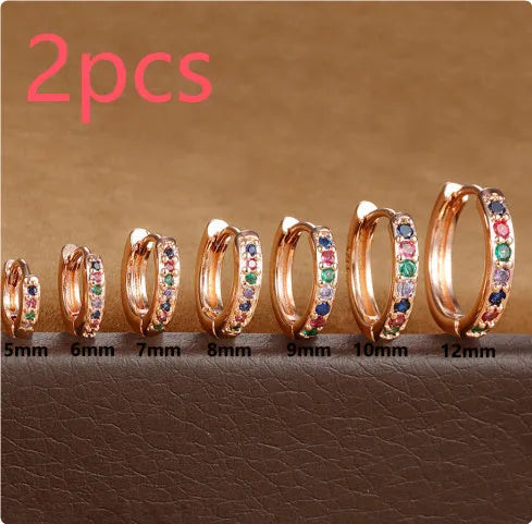 Gold, rose gold, and silver coloured circle-shaped zircon stud earrings on a white background.