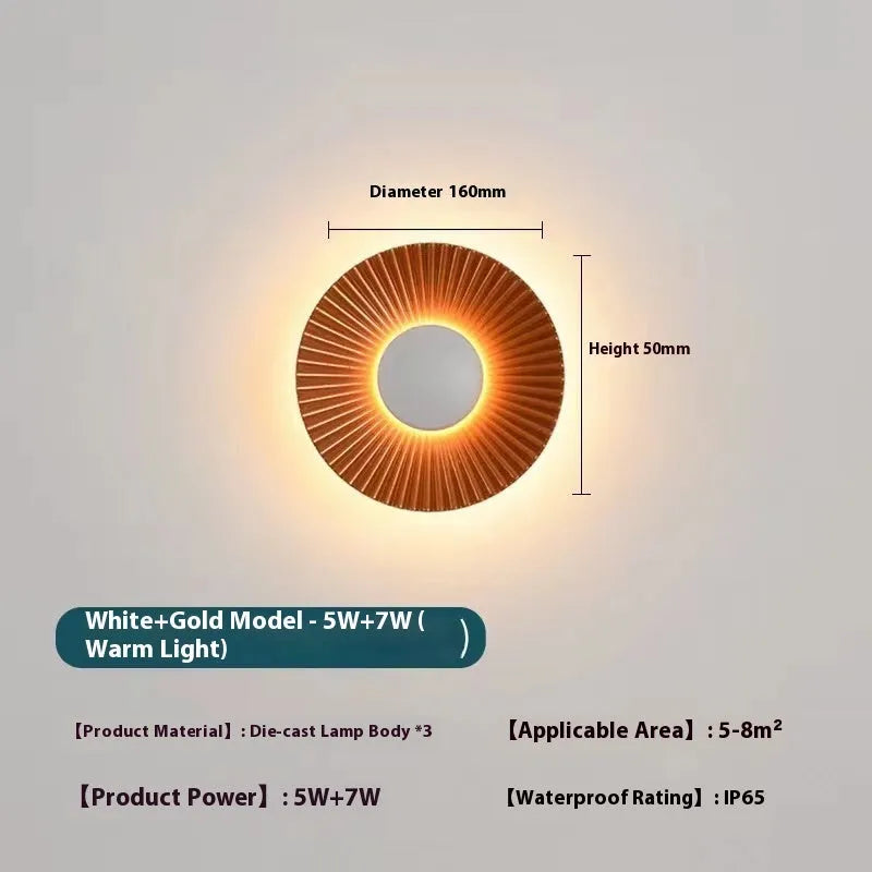 Round aluminium wall lamp with outer white and inner gold finish mounted on a wall