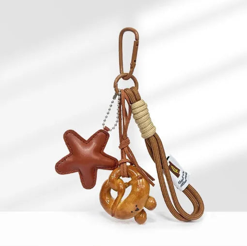 Handmade brown star resin handbag pendant with cartoon soda bread design on a brown strap