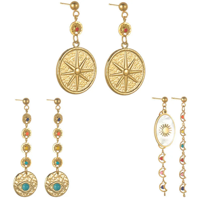 Stainless steel geometric drop earrings showing eight-awn star, eye, and shell sun designs in silver tone
