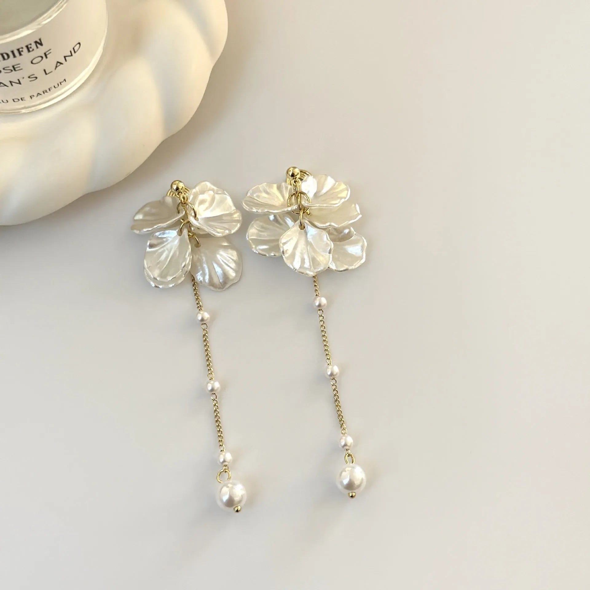 Women's acrylic shell pearl tassel earrings showing four different clip style options