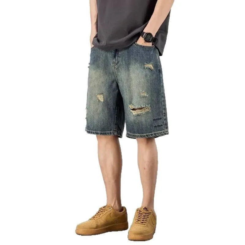 Men's blue distressed denim shorts with a straight leg and retro hole detailing.