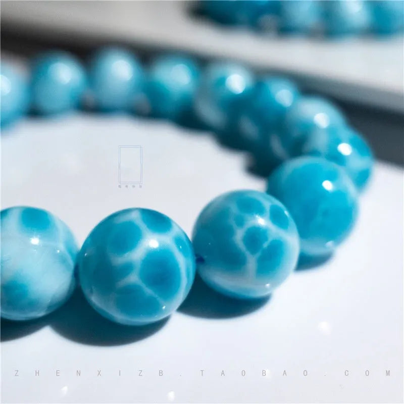 Blue Maillard style Bodhi bracelet with a natural sea-pattern crystal stone and pearl beads on wrist.