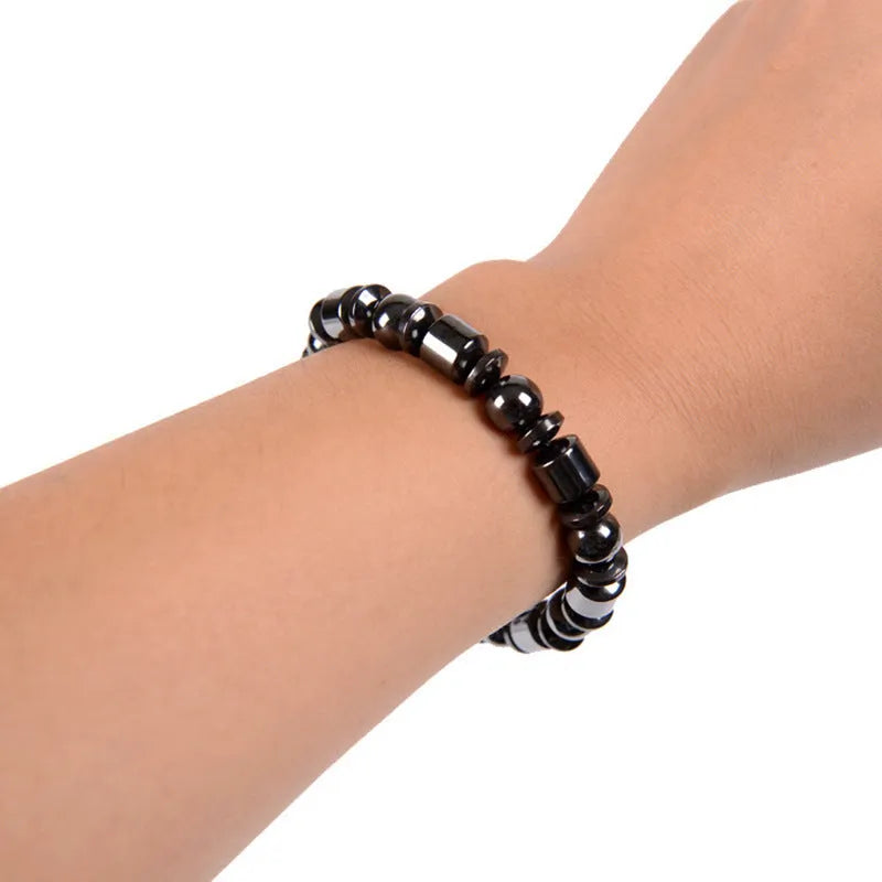 Black pentagram magnetic bracelet with magnetite and hematite stones on a wrist.