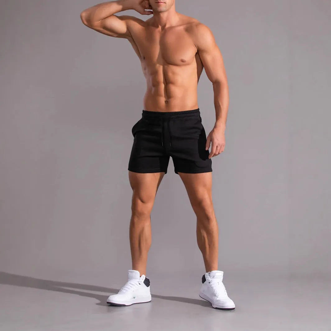 Three pairs of men's solid colour shorts in black, khaki and light brown with drawstring waists
