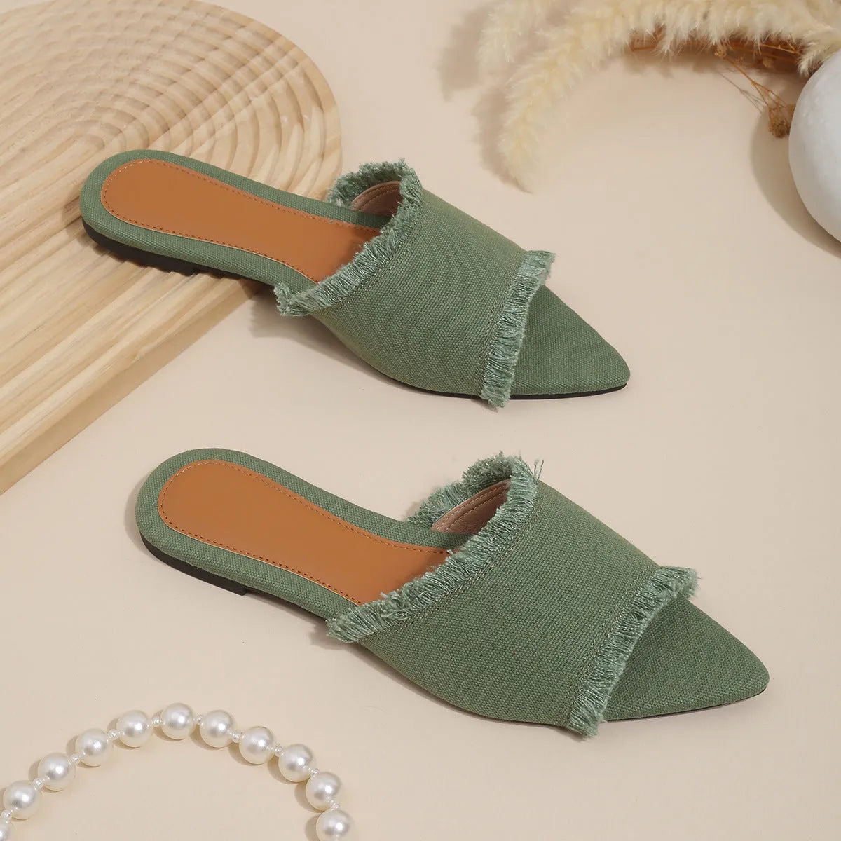 Women's denim flat slippers with tassel detail and leather lining in various colours.