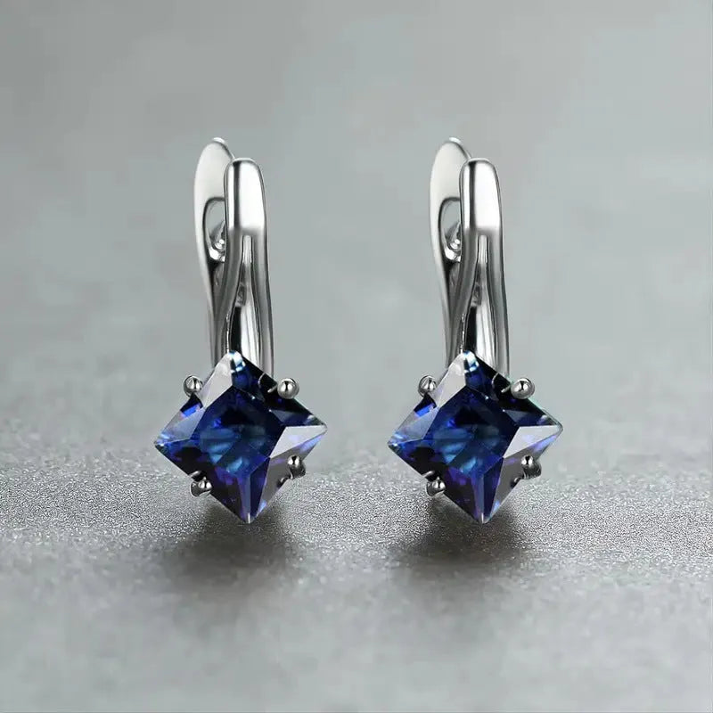 A pair of women's copper earrings with an inlaid zircon diamond design, shown in blue, green, and colour variations.